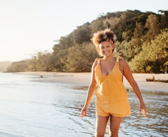 Happy woman in yellow jumpsuit by river